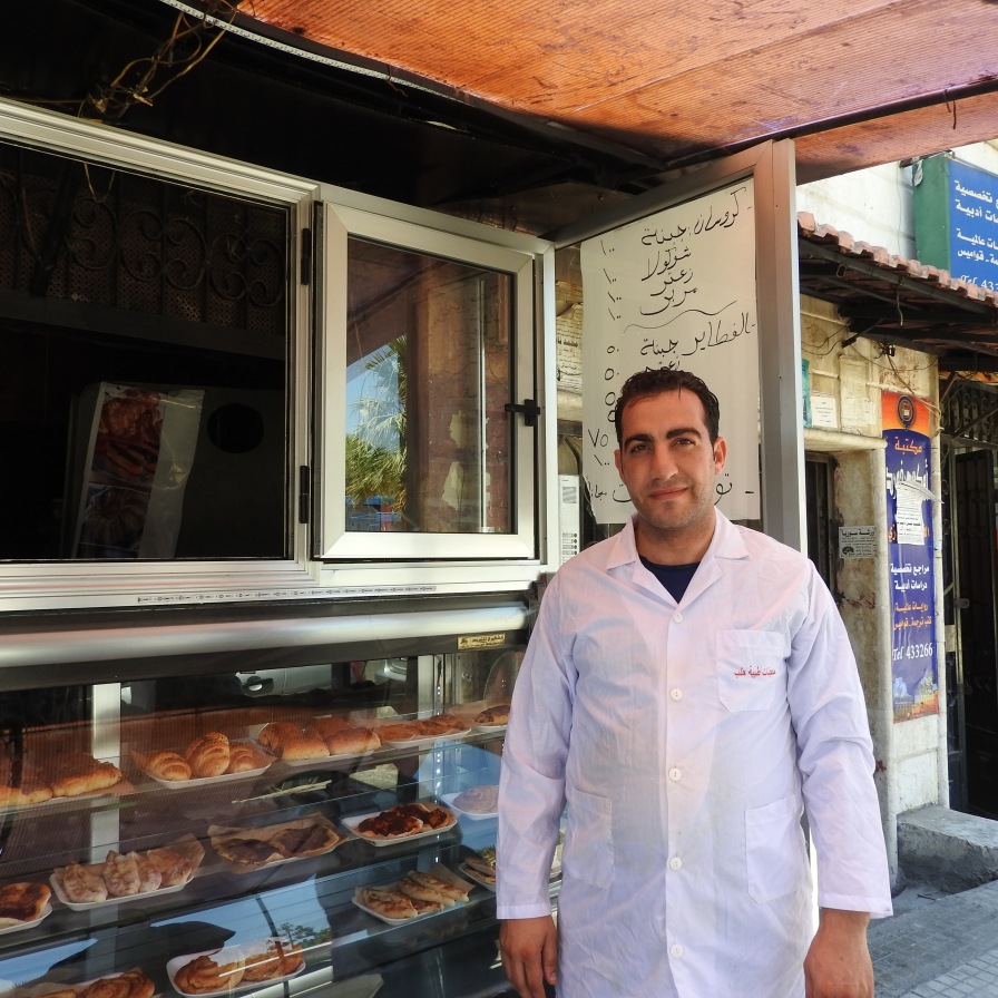Croissant shop owner is displaced from Aleppo, from one of the first areas to be infested by terrorists. He lost he three apparently very-well known and loved croissant/bakery shops, all the equipment, his home and all furnishings when he and family fled the terrorists to Latakia. His personal loss also of course affected the 10 employees he had in Aleppo. Here, he worked for about 4 months in Jableh before opening his first croissant shop in Latakia, which has since blossomed into two apparently very popular croissant shops. More here: https://ingaza.wordpress.com/2016/08/11/updates-from-on-the-ground-in-syria-june-to-august-11/ or here: https://www.facebook.com/EvaBoBeeva/posts/1244053205604671