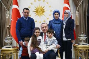 Turkey's President Recep Tayyip Erdogan,accompanied by his wife Emine, standing 2nd right, poses for pictures with the family of Bana Al-Abed, seated on his lap left, 7, from Aleppo, Syria, at his Presidential Palace in Ankara, Turkey, Wednesday, Dec. 21, 2016. The Syrian child who became the civilian face of Aleppo – 7-year old Bana Al-Abed whose tweets of life under siege in Aleppo went viral and who was evacuated from Aleppo was greeted along with her family by Erdogan on Wednesday. Mother Fatemah Al-Abed, right, and father Ghassan Al-Abed, name of other sibling is not available.(Presidency Press Service via AP, Pool)
